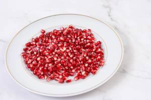 Fresh Pomegranate on the plate above grey marble table (Flip 2019)