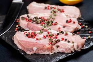 Fresh pork steaks with a mix of peppers peas, close -up (Flip 2020)