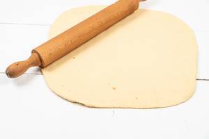 Fresh raw Dough with wooden Rolling Pin
