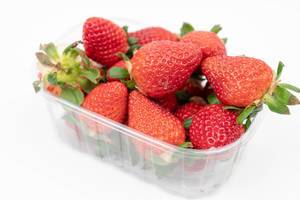 Fresh Raw Strawberries in the plastic box above white background