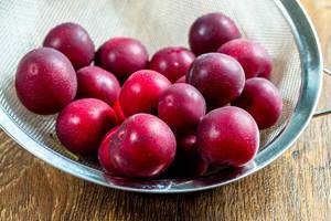 Fresh red plums in a sieve (Flip 2019)