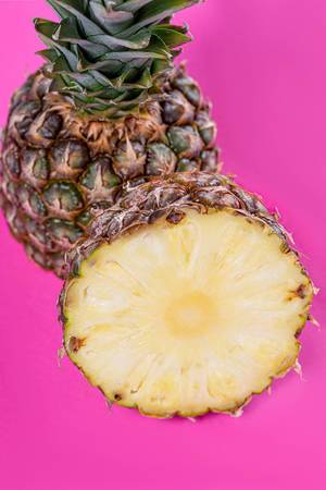 Fresh ripe pineapple halves on pink background (Flip 2019)