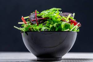 Fresh salad with a mixture of different lettuce and arugula in a black bowl (Flip 2019)