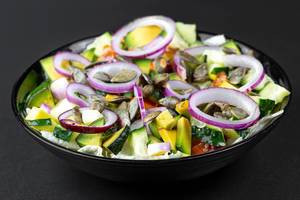 Fresh salad with sliced vegetables, purple onion rings and pumpkin seeds (Flip 2020)