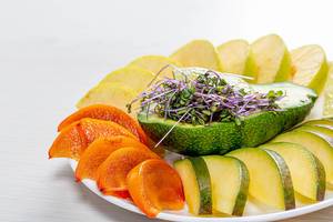 Fresh slices of mango, persimmon, Apple, lime and avocado with micro greens