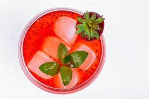 Fresh summer cocktail with strawberry and ice cubes. Top view