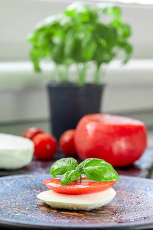 Fresh tomatoes, mozzarella cheese and Basil on the kitchen table
