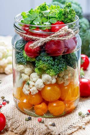 Fresh vegetables stacked in layers in a glass jar close up (Flip 2019)