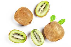Fresh whole and slices of kiwi on a white background, top view (Flip 2020)