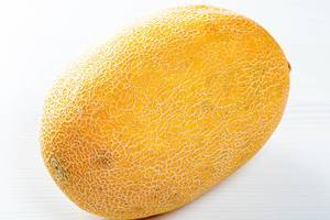 Fresh yellow melon on white wooden table
