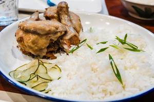 Fried chicken covered in gravy served with rice