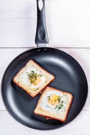 Fried eggs with bread and herbs in a frying pan (Flip 2019)