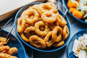Fried onion rings and other tasty snacks on a table