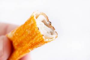 Fried Surimi Sticks in the hand above white background