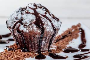 Frisch gebackener Schokoladenmuffin mit Schokoladendekoration mit Schärfentiefe fotografiert