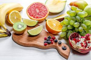 Frische gereifte Früchte, Obst und Beeren auf weißem Holztisch