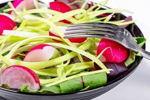 Frischer vegetarischer Salat mit Blattspinat, Radieschen und Lauch in Nahaufnahme