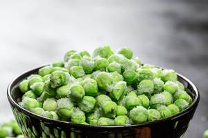 Frozen green peas in a bowl closeup