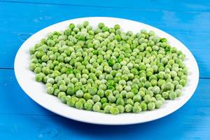 Frozen Green Peas on the white plate