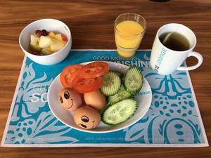Frühstück mit Obstsalat, O-Saft, Gurken, Tomaten und Eiern