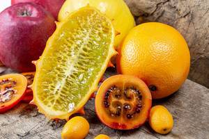 Fruit background with fresh citrus, quince, apples, sliced tamarillo and kiwano (Flip 2020)