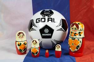 Fußball hinter Matrjoschkapuppen auf einer russischen Flagge