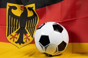 Fußball mit Flagge Deutschlands im Hintergrund