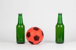 Fußball zwischen zwei Bierflaschen