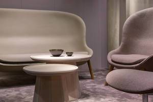 Futuristische Wohnzimmereinrichtung mit Sofa und Sessel in abgerundeter Form und runden Tischen