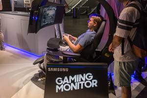 Gamer sitting in a gaming chair and playing on a super ultra-wide monitor