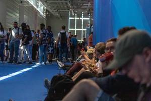 Games fair visitors taking a break from Gamescom while sitting on the floor and having lunch