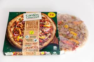 Garden Gourmet Protein Lovers Pizza mit Leinsamen, Quinoa und pulled Soybeans ragt aus der Verpackung