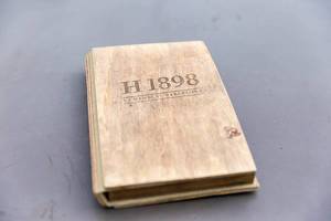 Gästebuch mit Holzcover des Hotel 1898 auf der La Rambla in Barcelona auf grauem Untergrund