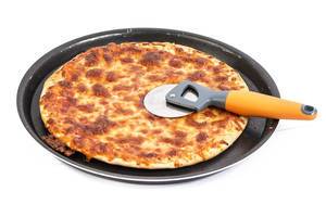 Gebackene Pizza Margherita auf einem runden Backblech mit einem Pizzaschneider