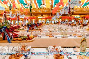 Gedeckte Tische mit Brezeln und Deko bei einem von den großen Festzelten beim Oktoberfest in München