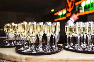 Gefüllte Champagnergläser auf Serviertabletts in einer Bar