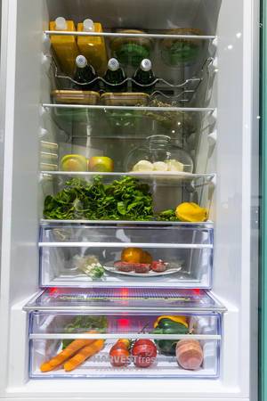 Gefüllter Kühlschrank von Grundig, mit Weinregal, Salat, Saft und frischem Obst & Gemüse