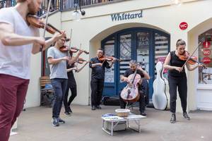 Geigenspieler und Cellospieler vor einer Tea Bar in London