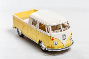 Gelbes Volkswagen Spielauto für Kinder auf einem Holztisch