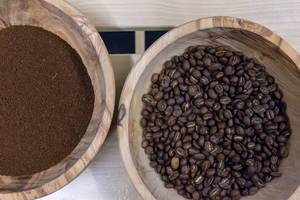 Gemahlener Bio Kaffee und Kaffeebohnen in Holzschalen  - Aufsicht