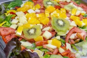 Gemischter Salat mit Früchten und Gemüse - Kiwi, Orangen, Apfel, Tomaten, Paprika