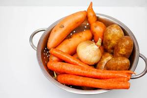Gemüse im Sieb: Karotten, Süßkartoffeln, Kartoffeln und Zwiebel