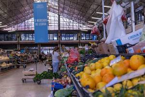 Gemüsestände mit Verkäuferin am Timeout Market in Lissabon