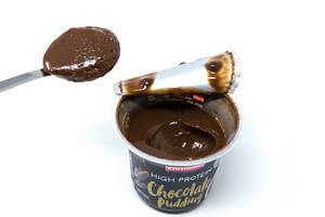 Geöffneter proteinreicher Schokoladenpudding von Ehrmann mit Löffel