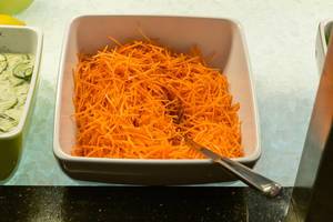Geraffelte Karotten in eckiger Schale auf Eis in Salatbuffet