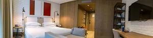 Geräumiges Hotelzimmer mit Doppelbett, Stehlampen und Bettbank im "The Corner Hotel" Barcelona, Spanien