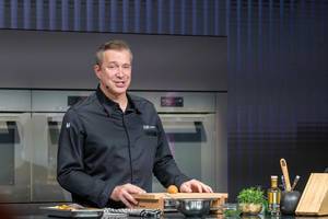 German chef cooks with Miele kitchen products during a live cooking show at IFA exhibition