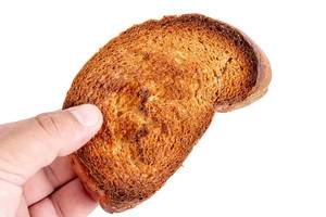Geröstetes Brot in der Hand vor weißem Hintergrund