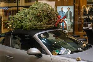 Geschmückter Weihnachtsbaum auf Autodach eines Cabriolets