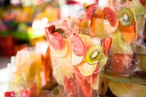 Geschnittene, tropische Früchte wie Kiwi, Apfel und Erdbeere abgefüllt in Plastiktüte